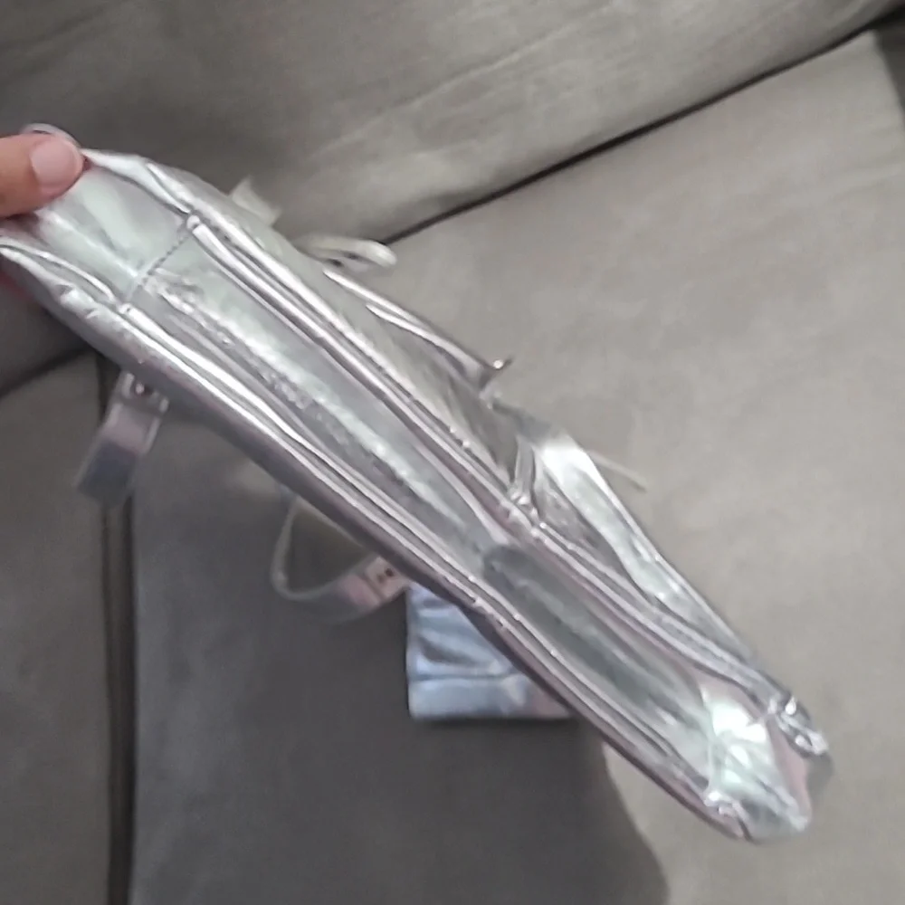 Shiny silver metallic handbag. Outside pockets snap closure‎ clean inside